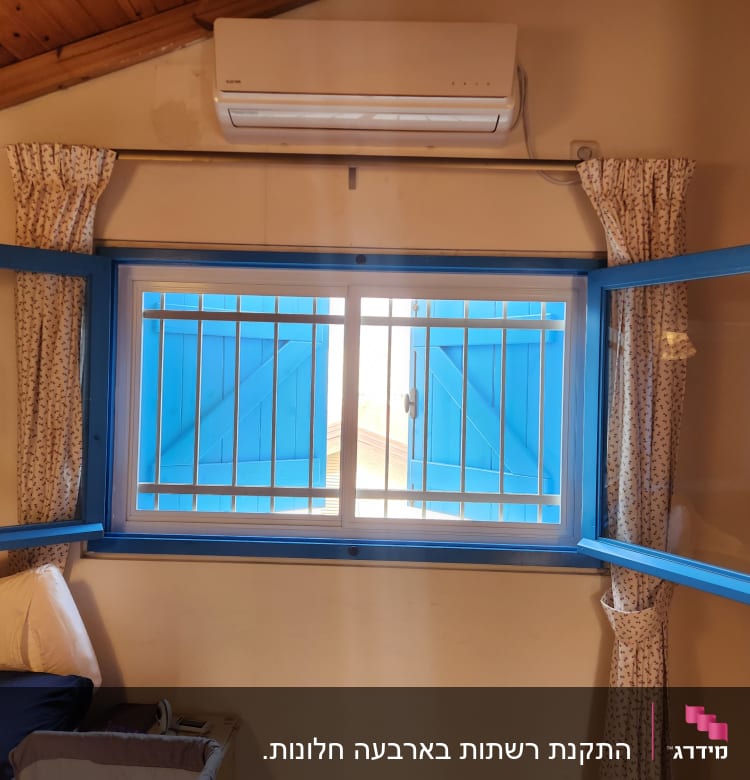 חלון עם מסגרת אלומיניום כחולה וסורגים